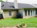 View of the backyard with a grill and a partial view of the side of the house at 2350 Laurel Pointe Ln, Lawrenceville, GA 30043