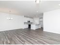 Open-concept living room featuring a kitchen with white cabinets and an island with pendant lights at 3021 Cambridge Mill St, Acworth, GA 30102