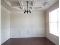Dining room featuring elegant ceiling detail, classic wainscoting, and gleaming hardwood floors at 1205 Apple Blossom Dr, Cumming, GA 30041
