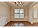 Bright dining area featuring a tray ceiling, chandelier, hardwood floors, and wainscoting at 1205 Apple Blossom Dr, Cumming, GA 30041