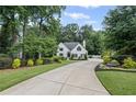 Elegant white home with an inviting driveway, lush landscaping, and well-maintained lawn, creating a serene atmosphere at 3648 Sope Creek Farm Se, Marietta, GA 30067