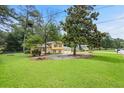 This two-story home with a two-car garage sits on a large, grassy lot with mature trees at 423 Mephisto Cir, Lawrenceville, GA 30046