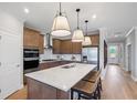 Modern kitchen with stainless steel appliances, an island with seating, and pendant lighting at 137 Kenney Way, Locust Grove, GA 30248