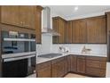 Well-equipped kitchen with stainless steel range hood, built-in oven, and custom cabinetry at 137 Kenney Way, Locust Grove, GA 30248