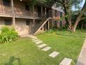 A beautifully landscaped building featuring a stone walkway, green lawn, and mature trees at 3117 Colonial Way # G, Atlanta, GA 30341