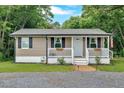 Cozy single-story home boasts neutral siding, black shutters, and a white-railed front porch at 104 Gilreath Rd, Cartersville, GA 30121