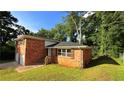 Side view of the red brick home featuring a well-manicured lawn at 2390 Tiffany Pl, Decatur, GA 30035