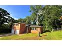 Charming home featuring red brick exterior, green lawn, and a driveway leading to a two-car garage at 2390 Tiffany Pl, Decatur, GA 30035