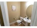 Neutral powder room featuring a pedestal sink, round mirror, and modern fixtures; clean and efficient design at 366 Highbranch Cir, Lawrenceville, GA 30044