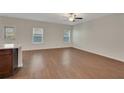 The living room features wood floors, a ceiling fan, two windows and bar access to the kitchen at 10814 Wheeler Trce, Hampton, GA 30228