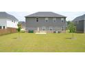 Large, private backyard with lush green grass and mature trees, perfect for outdoor entertaining at 1612 Fuma Leaf Way, Mcdonough, GA 30253