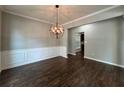 Elegant dining room featuring crown molding, wainscoting and modern chandelier at 944 Reap Ln, Lawrenceville, GA 30043