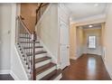A home entryway with hard wood floors, stairs to the upper level, and white trim at 11686 Davenport Ln, Alpharetta, GA 30005