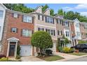 Attractive townhomes with brick and siding exteriors, attached garages, and well-maintained lawns at 3068 Lauren Parc Rd, Decatur, GA 30032