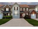 Charming townhome featuring a one car garage, red front door, manicured lawn, and inviting curb appeal at 2924 Greyhawk Ln, Cumming, GA 30040