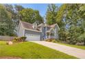 Two-story home with a well-manicured lawn, attractive landscaping, and a long driveway leading to a two-car garage at 3866 Teresa Sw Ter, Lilburn, GA 30047