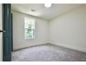An empty bedroom with neutral colored walls and carpeting, along with a window to let in light at 5023 Rockborough Trl, Norcross, GA 30071
