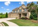 Charming two-story brick home with a three-car garage, a covered front porch and a large front yard at 2330 Cheatham Creek Ct, Cumming, GA 30040