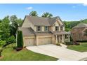 Charming two-story brick home with a three-car garage, a covered front porch and a large front yard at 2330 Cheatham Creek Ct, Cumming, GA 30040