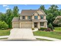Charming two-story brick home with a three-car garage and landscaped front yard in daylight at 2330 Cheatham Creek Ct, Cumming, GA 30040