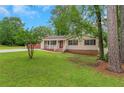 Well-maintained home with green lawn, mature trees, and welcoming front porch, offering great curb appeal at 25 Carriage Ct, Stockbridge, GA 30281