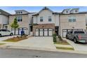 Inviting townhome showcasing a two-car garage, classic brickwork, and professional landscaping at 94 Depot Landing Rd, Auburn, GA 30011