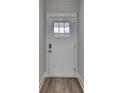 Classic white front door with glass pane and modern hardware set against a neutral wall at 94 Depot Landing Rd, Auburn, GA 30011
