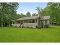 Inviting single-story home with a charming front porch and well-manicured lawn at 1267 Austin Bridge Rd, Douglasville, GA 30134