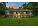 Charming single-story home at dusk with a welcoming front porch and lush green lawn at 1267 Austin Bridge Rd, Douglasville, GA 30134