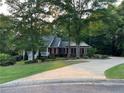 Traditional brick home features a white porch, manicured lawn, and a winding driveway at 19 Thimblemill Ct, Villa Rica, GA 30180
