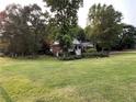 Brick house with white trim is surrounded by mature trees and green lawn at 19 Thimblemill Ct, Villa Rica, GA 30180