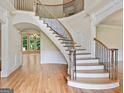 Elegant entryway with a curved staircase, hardwood floors, and decorative wrought iron railings at 6205 Arnall Nw Ct, Acworth, GA 30101