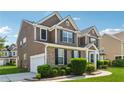 A lovely two-story house showcasing siding and brickwork, with a lush lawn and a paved driveway at 3134 Flery Way, Lawrenceville, GA 30046