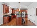 Well-equipped kitchen features dark wood cabinets, granite countertops, and stainless steel appliances at 3134 Flery Way, Lawrenceville, GA 30046