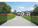 Elegant driveway leading to a beautiful home, enhanced by wrought iron gates at 4539 Braselton Hwy, Hoschton, GA 30548