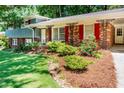 Close-up of a well-maintained home featuring brick accents and colorful landscaping in a lush, green yard at 5152 Suggs St, Powder Springs, GA 30127