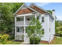 Attractive two-story home with a double porch, complemented by lush greenery and mature trees at 315 Melrose Ave, Decatur, GA 30030