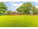 Spacious front yard featuring a well-maintained lawn and a quaint, single-story brick house at 2696 Eldorado Pl, Snellville, GA 30078