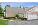 Home featuring a two-car garage and neutral siding and stone accents at 6107 Malloway Ct # B-6107, Cumming, GA 30041