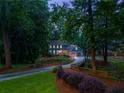 Serene twilight view of a blue two-story home with attached garage, set amidst lush greenery and mature trees at 7250 Hunters Branch Dr, Atlanta, GA 30328