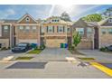Row of townhomes showcases garages, neutral paint, and meticulous landscaping along the driveways at 2235 Mulsanne Dr, Lithonia, GA 30058