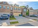 Exterior view of townhomes featuring attached garages, manicured lawns, and variety of exterior materials at 2235 Mulsanne Dr, Lithonia, GA 30058