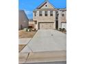 Street view of a two-story townhome with a brick front and a two-car garage at 2240 Mulsanne Dr, Lithonia, GA 30058