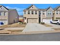Two-story townhome with brick facade and two-car garage on a sunny day at 2240 Mulsanne Dr, Lithonia, GA 30058
