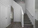 Bright foyer showcasing staircase with white railing and a glimpse into other rooms with modern, light flooring at 250 Shawnee Trl, Dallas, GA 30157