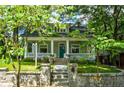 Charming home with a welcoming front porch, stone stairs, and lush green lawn at 630 Cleburne Ne Ter, Atlanta, GA 30306