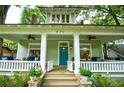 Charming porch with ceiling fans, white columns, and a bright teal front door at 630 Cleburne Ne Ter, Atlanta, GA 30306