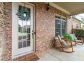 Inviting front porch with brickwork, rocking chairs, decor, and a welcoming entrance to the home at 1771 Silvergrass Ln, Grayson, GA 30017