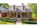 Lovely home showcasing a welcoming front porch, brick facade, and lush landscaping at 180 Mountain Path, Rockmart, GA 30153