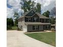 Traditional two-story home with a long driveway leading to a two car garage at 3030 Fairway Dr, Villa Rica, GA 30180